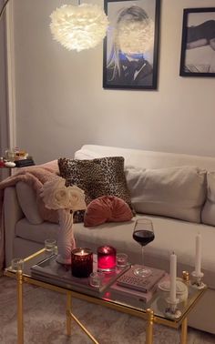 a living room with a couch, coffee table and two pictures on the wall above it