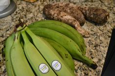 some green bananas are sitting on a counter