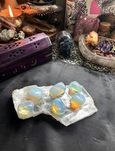 four soap bubbles sitting on top of a table next to other items and candles in the background