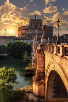 the sun is setting over an old bridge in rome, italy with roman architecture behind it