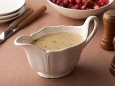 there is a bowl of soup on the table with utensils next to it