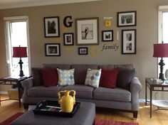 a living room filled with furniture and framed pictures on the wall above it's coffee table