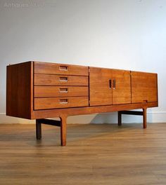 a large wooden cabinet sitting on top of a hard wood floor next to a wall