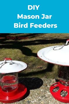 two red and white bird feeders sitting next to each other on top of grass