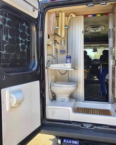 the interior of an all - terrain vehicle with its door open and toilet in it