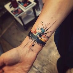 a person's arm with a colorful ink splattered design on the wrist