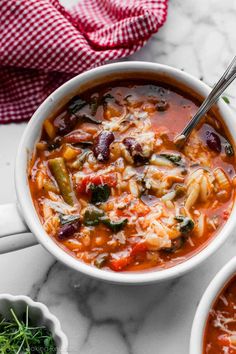 two bowls of pasta soup on a marble table