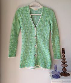 "A '60s knit sweater / cardigan by Blairmoor that is straight outta Swinging London. Features include:  + Vibrant green, aqua & white hues across an intricate zig-zag pattern + 100% acrylic + White piping on deep V-neck & front panels + Mod white buttons with silver trim + Slim fit that extends below the hips + Blairmoor tag intact Condition: excellent ---------------------------------- Measurements taken lying flat:  Fit: XS Bust: Open / 15.5\" across with buttons fastened Waist: 13\" Length: 26 3/4\" Sleeve Length: 23\" Please let me know if you have any questions -- happy to help!" Vintage Knitted V-neck Outerwear, Vintage V-neck Knitted Outerwear, Retro Long Sleeve Knit Cardigan, Vintage V-neck Knit Cardigan, Vintage Green Knit Outerwear, Retro Green V-neck Sweater, Fitted Long Sleeve Retro Cardigan, Vintage Knit V-neck Cardigan, Retro Fitted Cardigan For Winter