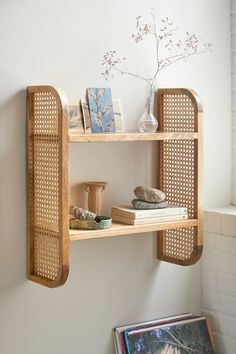 a wooden shelf with books and vases on it