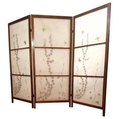 a room divider with flowers and leaves on the glass panels, set against a white background