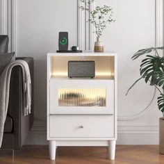 a living room with a couch and a white cabinet next to a potted plant