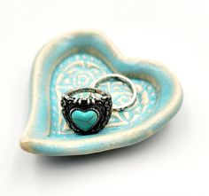 a heart shaped dish with a ring on it