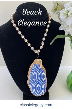 Our oyster shell necklace features a blue and white ikat design that has a gold leaf border.   The back side is also gold leaf.   The neck chain is a 15" pearl link lin with a silver toggle closure.   This necklace is one of a kind since we use real oyster shells.  The shell shown is 4" long and 2" wide.   The oyster shells in this design will be very similar to this.  Know that you are purchasing a unique hand-made gift. Lake Gifts, Leaf Border, Ikat Design, Great Wedding Gifts, Shell Ring, Oyster Shells, Neck Chain, Shell Necklace, Shell Art