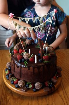 Berry Chocolate Birthday Cake - Three layer chocolate cake filled with chocolate mousse and frosted with chocolate buttercream frosting and dripping dark chocolate ganache, then topped with strawberries, blueberries, ferrero rocher candy and various chocolate bars.  (Plus some rosemary leaves as garnish) Rustic Chocolate Cake Birthday, Chocolate Celebration Cake Birthdays, Chocolate Fruit Cake Birthday, Cake With Ferrero Rocher On Top, Chocolate 30th Birthday Cake, Dark Chocolate Birthday Cake, Chocolate Birthday Cake With Flowers, Dark Chocolate Cake Decoration