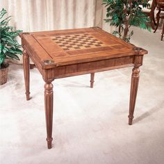 a wooden table sitting on top of a carpeted floor next to a potted plant