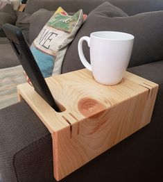 a cup is sitting on top of a wooden block with a tablet in the middle