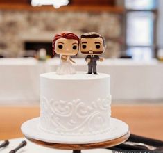 two figurines on top of a wedding cake