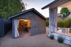 a garage with an open door and covered patio area in the back yard at dusk