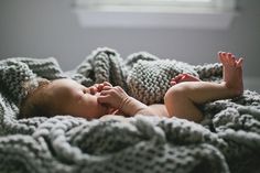 a baby is laying down on a blanket