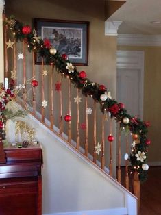 christmas decorations on the banisters and stairs in a home decorated with red, white and gold ornaments