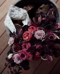 a bouquet of flowers sitting on top of a wooden floor next to a piece of cloth