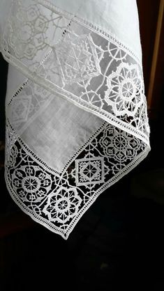 an embroidered white table cloth with intricate lace