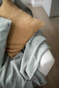 a bed with two pillows on top of it next to a blanket and pillow case