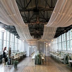 a room filled with lots of tables covered in white drapes