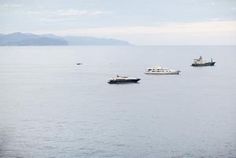 three boats floating in the water near each other