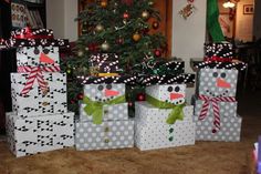 presents wrapped in black and white paper are sitting next to a christmas tree