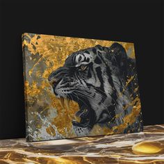 a painting of a tiger on a black background with gold paint splattered over it