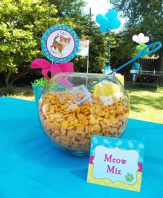 a bowl filled with dog treats next to a sign that says meow mix on it