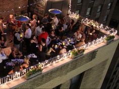 a group of people standing around tables with candles on them