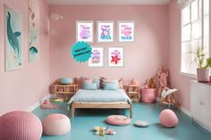 a bedroom with pink walls, blue flooring and pictures on the wall above the bed