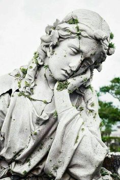 a statue with moss growing on it's face