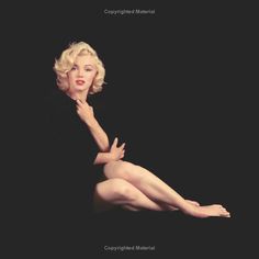 marilyn monroe is sitting on the ground with her legs spread out and hands behind her head