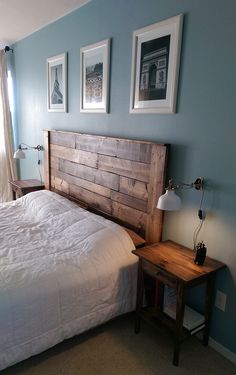 a bed sitting in a bedroom next to two framed pictures on the wall above it