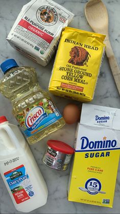 ingredients to make chocolate cake laid out on a marble counter top, including eggs, milk, flour, butter, and sugar