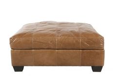 a brown leather ottoman sitting on top of a white floor