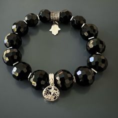 The Black protection Symbol Bracelet is great if you're looking for a sleek and stylish look. I elevated the look and feel of faceted black onyx stone beads with silver and silver and onyx butterfly charm and a sparkly Swarovski bead with hamsa charm to create this elegant piece. This bracelet is a great addition to any wardrobe and is both stylish and protective. Black Onyx Crystal resonates with the root chakra and it always has your back. Onyx Stone symbolizes change and spiritual journey. Us Elegant Obsidian Bracelets For Meditation, Luxury Adjustable Bracelets With Charms, Luxury Adjustable Charms Bracelets, Elegant Black Rosary Bracelet, Spiritual Black Beaded Bracelets With Stones, Elegant Evil Eye Bracelet With Round Beads, Spiritual Black Bracelets With Stones, Elegant Silver Obsidian Beaded Bracelets, Elegant Black Charm Bracelet For Gift