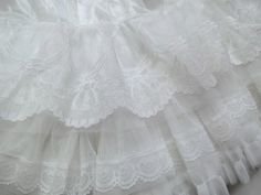 an image of white lace fabric with ruffles and crochet on it