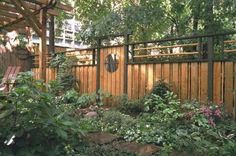 a wooden fence surrounded by plants and trees