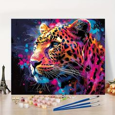 a painting of a leopard on a table next to some paintbrushes