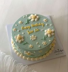 a blue birthday cake with flowers on it