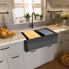 a kitchen with white cabinets and gray counter tops has an open sink in the center