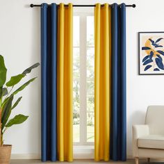 blue and yellow curtains hanging in front of a window with potted plant next to it