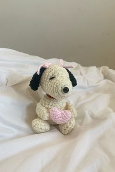 a small crocheted dog sitting on top of a bed