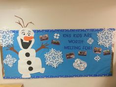 a bulletin board with a snowman on it and some pictures hanging from the wall