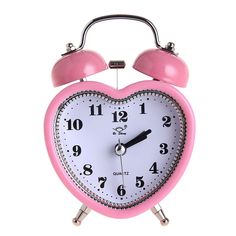 a pink and white heart shaped alarm clock with two bells on each side, against a white background