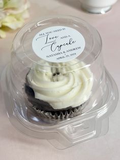 a cupcake with white frosting in a plastic container